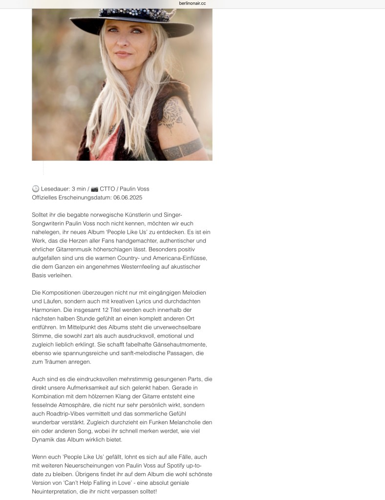 Portrett av den norske artisten Paulin Voss iført en svart hatt og en tanktop, med tatoveringer synlig på armen.